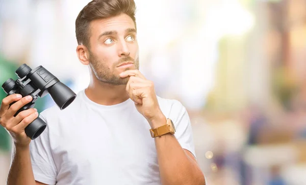 Young Handsome Man Looking Binoculars Isolated Background Serious Face Thinking — Stock Photo, Image