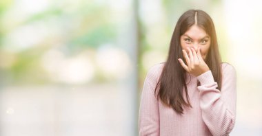 Umutla parmak ile burun üzerinde giyen bir kazak bir şey pis ve iğrenç kokulu, dayanılmaz koku, genç güzel İspanyol kadın. Kötü kokuyor kavramı.