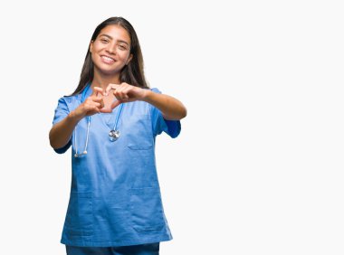 Genç Arap Doktor cerrah kadın kalp simgesi ve elleriyle şekil gösterilen aşık gülümseyen izole arka plan yüzünden. Romantik kavramı.