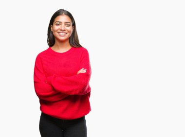 Üzerinde kış kazak giyen genç güzel Arap kadın mutlu yüz ile gülümseyerek kameraya seyir silah geçti arka plan izole. Olumlu bir kişi.