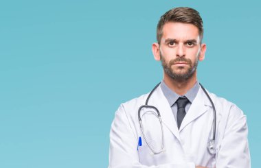 Genç yakışıklı Doktor adam izole arka plan şüpheci ve sinir, onaylamayan ifade yüz çapraz kolları üzerinde. Negatif kişi.