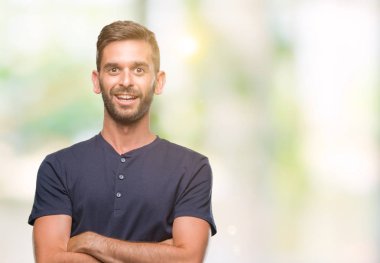 İzole arka plan mutlu yüz çapraz silah kameraya bakarak ile gülümseyen genç yakışıklı adam. Olumlu bir kişi.