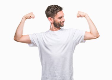 Yakışıklı genç gururlu gülümseyen kol kasları gösterilen izole arka plan üzerinde. Fitness kavramı.