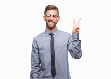 Genç yakışıklı iş adamı mutlu yüz zafer işareti yaparken kameraya göz kırpıyor ile gülümseyen izole arka plan üzerinde. İki numaralı.
