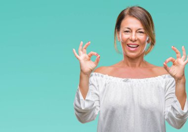 Orta yaş izole arka plan üzerine İspanyol kadın kıdemli sakin ol ve gülümseyen gözlerle parmak ile meditasyon jest yapıyor kapalı. Yoga kavramı.