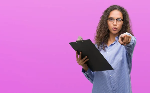 Joven Mujer Negocios Hispana Sosteniendo Portapapeles Señalando Con Dedo Cámara —  Fotos de Stock