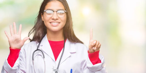 年轻的阿拉伯医生妇女在孤立的背景显示和指向手指数六 而微笑着自信和快乐 — 图库照片