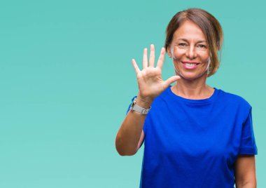 Orta yaş üst düzey İspanyol kadın gösterilen ve parmakları ile işaret izole arka plan yüzünden kendinden emin ve mutlu gülümseyerek süre beş numara.