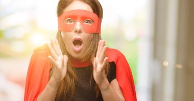 Kırmızı maske ve cape stresli tutmak ellerini kafasına, panik içinde dehşete giyiyor, bağırarak orta yaş süper kahraman kadın