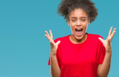 Genç afro Amerikan kadın deli kutluyor ve silah ile başarı için heyecanlı çığlık kaldırdı ve açık gözleri hayret izole arka plan yüzünden. Kazanan kavramı