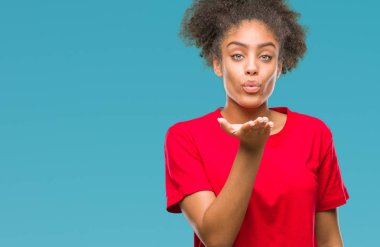 Bir öpücük el ile güzel ve seksi olmak hava üfleme kamera bakarak izole arka plan üzerinde genç afro Amerikalı kadın. Aşk ifade.