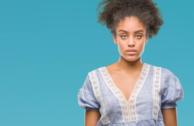 Yüzünde ciddi bir ifade ile izole arka plan üzerinde genç afro Amerikalı kadın. Basit ve doğal kameraya bakıyor.
