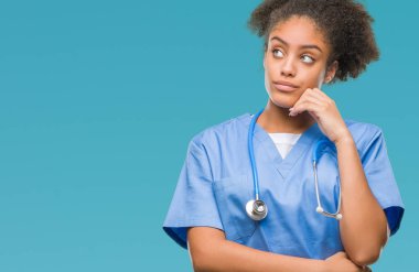 Genç afro Amerikalı doktor kadın elle çene düşünme hakkında soru, dalgın ifade izole arka plan yüzünden. Düşünceli yüzüyle gülümsüyor. Şüphe kavramı.