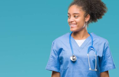 İzole arka plan uzak tarafına gülümseme ile yüzünde, doğal ifade seyir üzerinde genç afro Amerikalı doktor kadın. Kendine güvenen gülüyor.