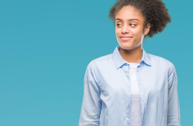 Genç afro Amerikalı kadın görünümlü yan ve dik dik bakma uzağa düşünce gülümseyen izole arka plan üzerinde.