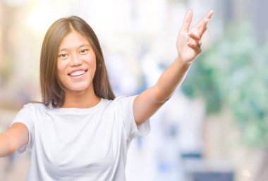 Sarılmak için kollarını açarak gülümseyerek kameraya bakarak izole arka plan üzerinde Genç Asyalı kadın. Neşeli ifade kucaklayan mutluluk.