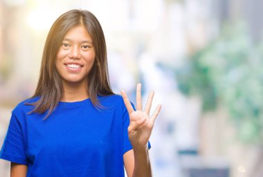 Genç Asyalı kadın gösterilen ve parmakları ile işaret izole arka plan üzerinde dört kendinden emin ve mutlu gülümseyerek iken numara.