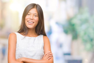 Genç Asyalı kadın izole arka plan mutlu yüz çapraz silah kameraya bakarak ile gülümseyen yüzünden. Olumlu bir kişi.