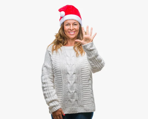 中年分離背景表示と指で上向きにクリスマスの帽子を身に着けている年配のヒスパニック系女性数は自信を持って 幸せな笑みを浮かべている間 — ストック写真