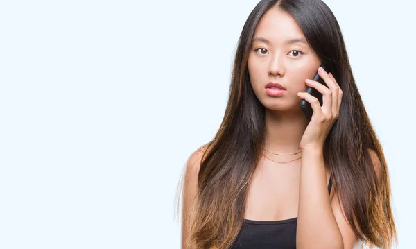 深刻な考えるスマートの顔に自信を持って式に孤立した背景に電話で話す若いアジア女性 — ストック写真