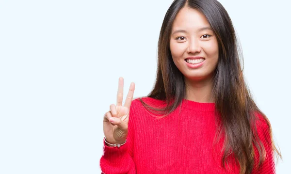 分離の背景表示と指で上向きに若いアジア女性着て冬セーター数は自信を持って 幸せな笑みを浮かべている間 — ストック写真