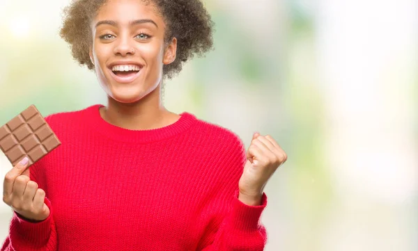 Junge Afroamerikanerin Isst Schokoriegel Vor Isoliertem Hintergrund Schreit Stolz Und — Stockfoto