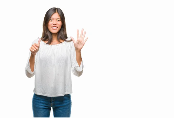 孤立した背景表示と指で上向きに若いアジア女性ナンバー 自信を持って 幸せな笑みを浮かべて — ストック写真