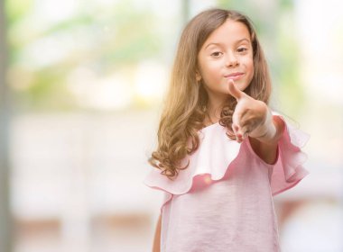 Tebrik ve davet edici dostu sunan karşılıklı gülümseyen pembe elbise esmer İspanyol kız. Başarılı iş.