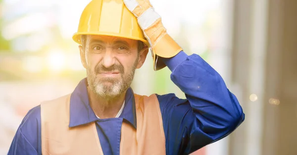 Senior engineer man, construction worker terrified and nervous expressing anxiety and panic gesture, overwhelmed