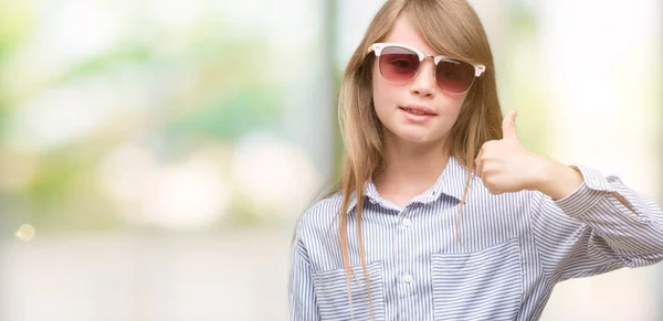 笑顔の サイン 優秀な兆候を親指をやって幸せな青いシャツを着ている若い金髪の幼児 — ストック写真