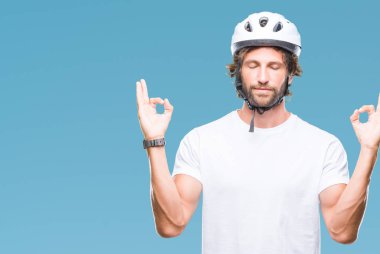 Yakışıklı İspanyol bisikletçi adam giyen Güvenlik kask izole arka plan üzerinde dinlenmek ve gülümseyen gözlerle parmak ile meditasyon jest yapıyor kapalı. Yoga kavramı.
