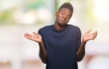 Afrikalı-Amerikalı genç izole arka plan clueless ve şaşkın bir ifadeyle kollar ve eller ortaya çıkar üzerinden. Şüphe kavramı.