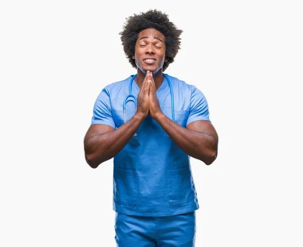 stock image Afro american surgeon doctor man over isolated background praying with hands together asking for forgiveness smiling confident.