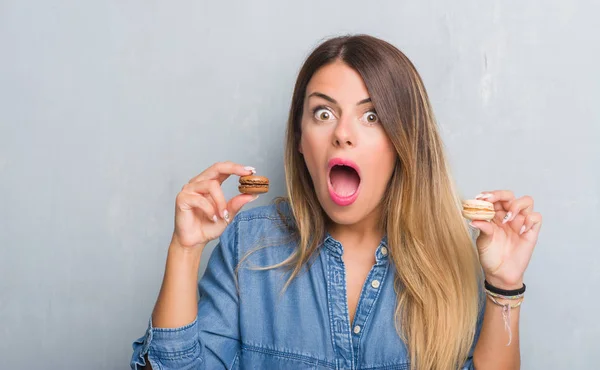 Mujer Adulta Joven Sobre Pared Grunge Gris Comiendo Macarrones Chocolate — Foto de Stock