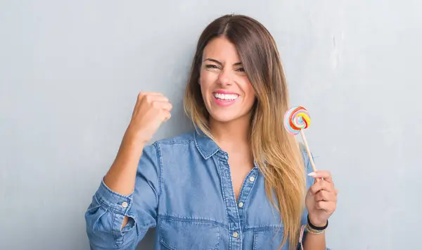 Young Adult Woman Grey Grunge Wall Eating Lollipop Candy Annoyed — Stock Photo, Image