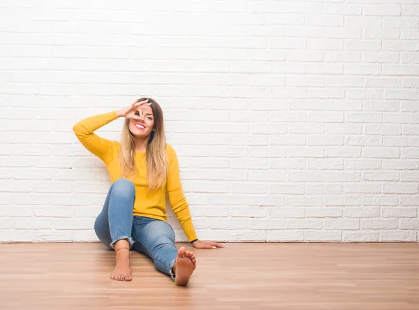 Ung Vuxen Kvinna Sitter Golvet Över Vit Tegelvägg Göra Gest — Stockfoto