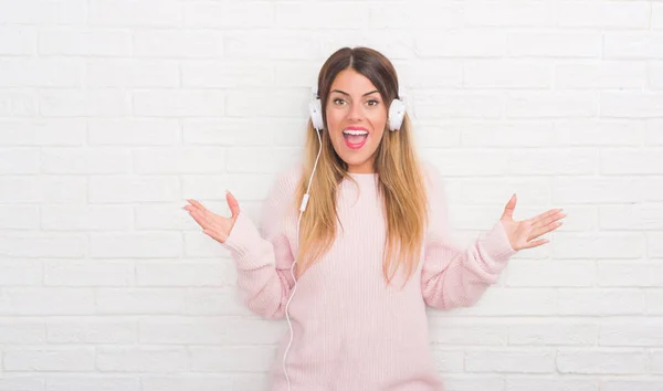 Mujer Adulta Joven Sobre Pared Ladrillo Blanco Usando Auriculares Escuchando —  Fotos de Stock