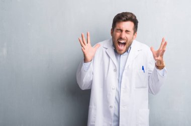 Yakışıklı genç profesyonel adam beyaz giyen gri grunge duvarın üzerinden kat kızgın ve başarı için deli kaldırdı kollarını açarak kutluyor ve heyecanlı çığlık kapalı gözler. Kazanan kavramı