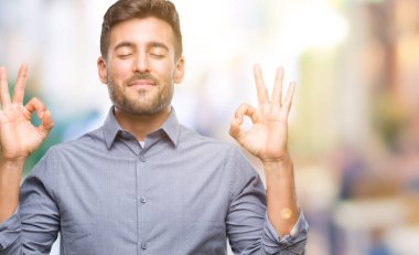 Yakışıklı delikanlı izole arka plan üzerinde dinlenmek ve gülümseyen gözlerle parmak ile meditasyon jest yapıyor kapalı. Yoga kavramı.