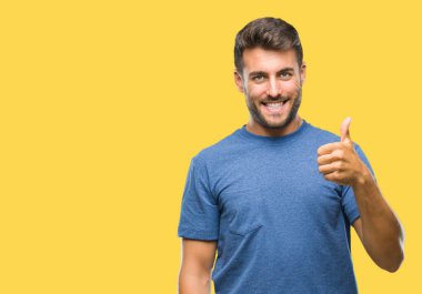 Yakışıklı delikanlı hareketi el ile mutlu yaşasın yapıyor izole arka plan üzerinde. Kameraya bakarak başarı gösteren ile ifade onaylama.