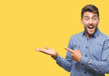 Yakışıklı delikanlı üzerinden hayran ve el ile sunulması ve parmak ile işaret ederken kameraya gülümseyen izole arka plan.