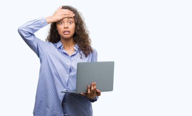 Bilgisayar dizüstü bilgisayar kafasına, el ile vurguladı tutan genç İspanyol kadın şok utanç ve sürpriz suratla, öfkeli ve sinirli. Korku ve hata için üzgün.