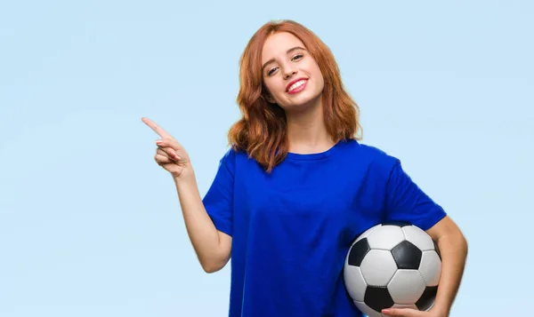 Молодая Красивая Женщина Изолированном Фоне Держа Футбольный Мяч Счастливо Указывая — стоковое фото