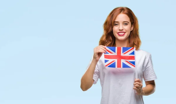 年轻美丽的妇女持有英国国旗在孤立的背景和一个快乐的脸站在微笑着自信的微笑显示牙齿 — 图库照片