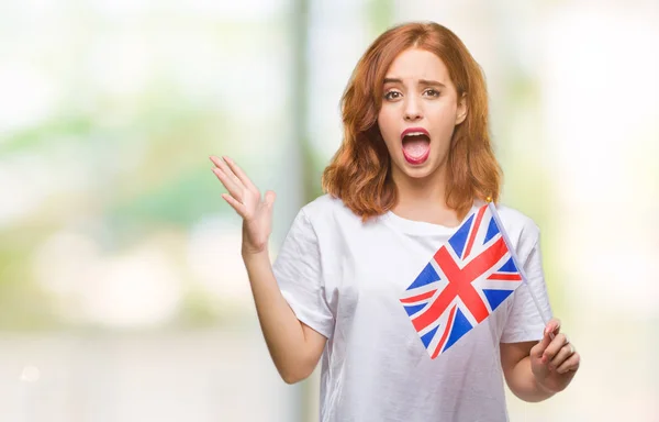 受賞式祝う勝利笑顔で叫び 手を上げた非常に幸せと興奮 孤立した背景の上イギリスの旗を保持している若い美しい女性 — ストック写真