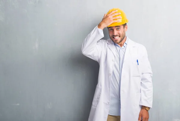 Bonito Jovem Engenheiro Homem Sobre Parede Grunge Cinza Usando Capacete — Fotografia de Stock