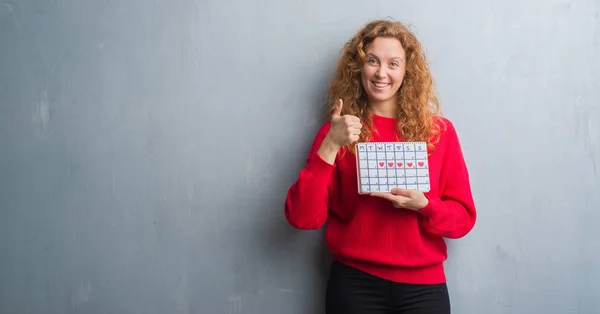 Joven Pelirroja Mujer Sobre Gris Grunge Pared Celebración Período Calendario — Foto de Stock