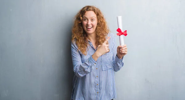 Jonge Roodharige Zakenvrouw Grijs Grunge Muur Met Diploma Erg Blij — Stockfoto