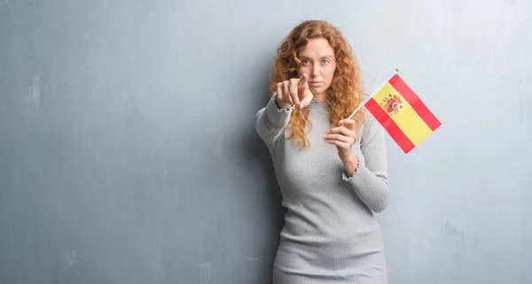 Joven Pelirroja Sobre Pared Grunge Gris Sosteniendo Bandera España Señalando —  Fotos de Stock