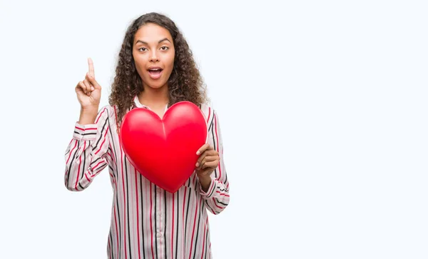 Joven Mujer Hispana Enamorada Sosteniendo Corazón Rojo Sorprendida Con Una — Foto de Stock